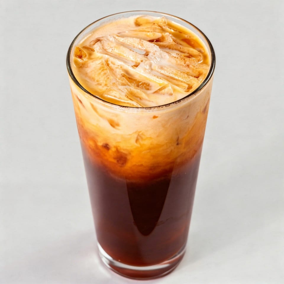 A tall glass of Phaya Thai Halal Restaurant's iced Thai tea with a creamy top layer.